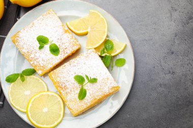 Lezzetli limonlu pudra şekeri, nane ve taze meyveli gri masa, düz yatak. Metin için boşluk