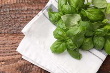 Taze fesleğen yaprakları ve ahşap masa üzerindeki peçete, üst manzara. Metin için boşluk