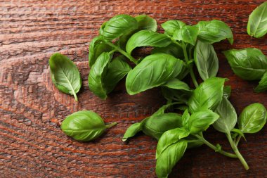 Tahta masada taze fesleğen yaprağı, düz uzanmış.