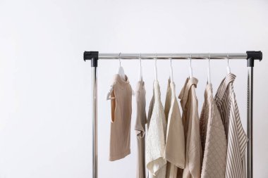 Farklı kadın kıyafetleri arka planda askıda asılı duruyor. Metin için boşluk