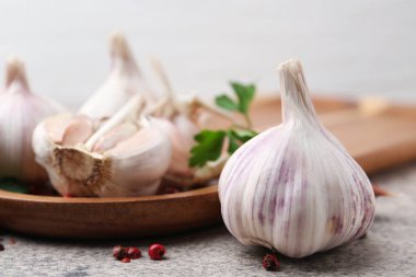 Garlic, peppercorns and parsley on light table, closeup
