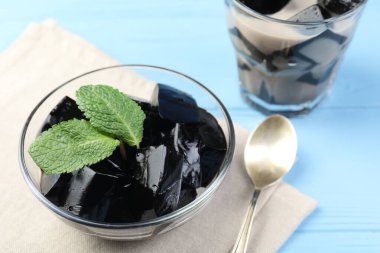 Açık mavi ahşap masada servis edilen naneli ve sütlü lezzetli bitkisel jöle.