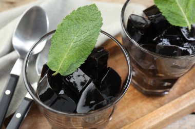 Ahşap masada servis edilen naneli tatlı bitkisel jöle, yakın plan.