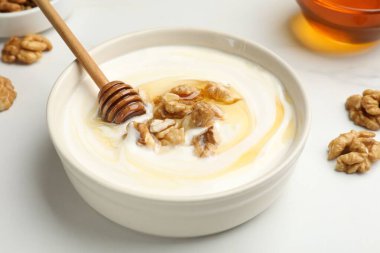 Beyaz masada bal ve fındıklı lezzetli Yunan yoğurdu, yakın plan.