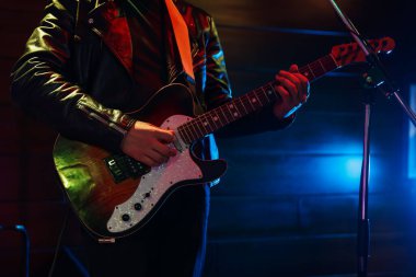 Sahnede elektro gitarlı bir adam, yakın plan.