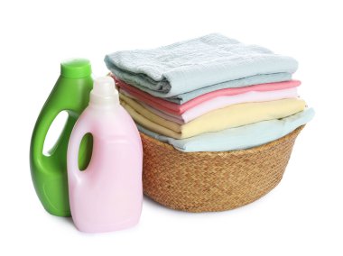Temiz giysiler ve beyaza izole edilmiş deterjanlarla dolu çamaşır sepeti.