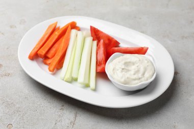 Açık gri masada farklı taze sebzeler ve sos, yakın plan.