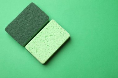 Mutfak süngerleri yeşil arka planda, düz yerde. Metin için boşluk