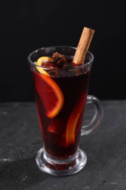 Siyah masada cam bardakta lezzetli bir şarap, yakın plan.