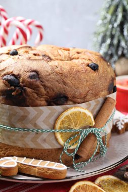 Tarçın çubuğu ve kuru portakal dilimiyle süslenmiş lezzetli bir Noel pastası. Yakın plan.