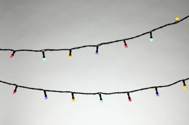 Gri arka planda parlak Noel ışıkları, yakın plan