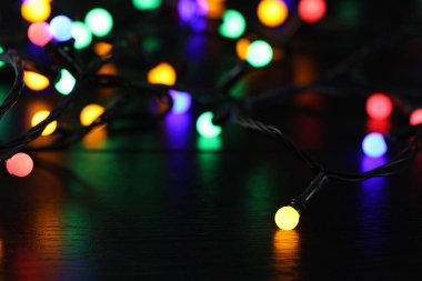 Parlak Noel ışıkları parlıyor Masada karanlıkta, yakın planda