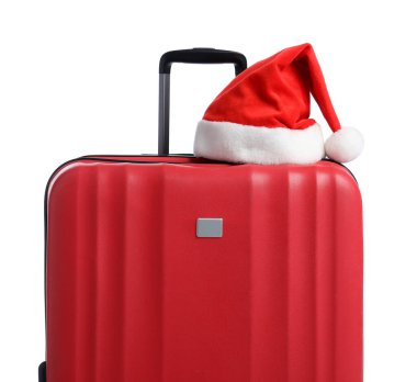 Beyaz arka planda kırmızı bavullu Noel Baba şapkası. Noel tatili