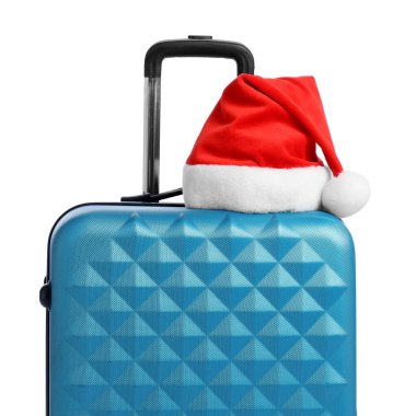 Beyaz arka planda mavi bavullu Noel Baba şapkası. Noel tatili