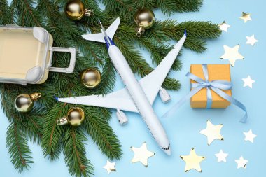 Noel tatili. Oyuncak uçak, bavul ve dekor açık mavi arka planda, düz yatıyordu