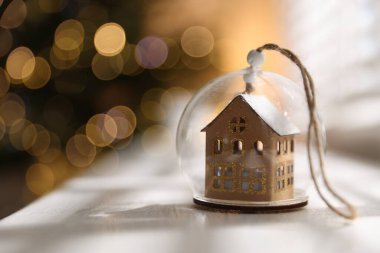 Beyaz masadaki güzel noel figürü kapalı alanda bulanık ışıklara karşı, metin için yer ile yakın çekim