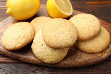 Lezzetli limonlu kurabiyeler ve meyveler ahşap masada, yakın plan.