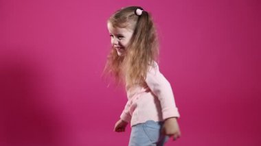 At kuyruklu şirin küçük kız pembe arka planda eğleniyor.