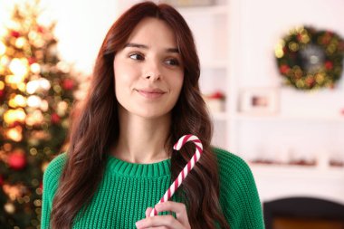 Noel için süslenmiş şeker kamışlı güzel bir kadın.