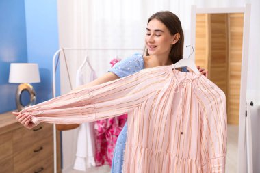 İçeriden giyinen çekici bir kadın. Kıyafet seçiyorum.