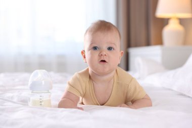 Evde yatağında biberonla beslenen tatlı bir bebek. Metin için boşluk