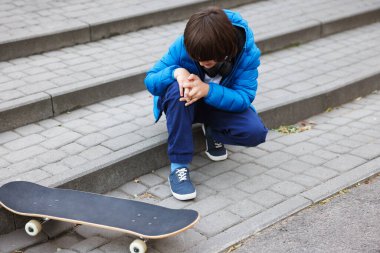 Dışarıdaki merdivenlerde kaykaylı küçük çocuk. Çocuk tehlikede.