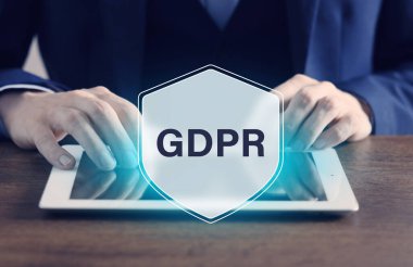 Genel Data Koruma Yönetmeliği. Tablet bilgisayar kullanan bir adam, yakın plan. GDPR kısaltmalı sanal kalkan. Gizlilik güvenliği