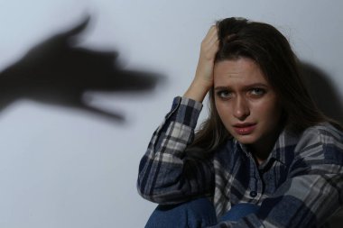 Fobi, patolojik korku. Korkmuş bir kadının yanında köpek şeklinde bir el gölgesi