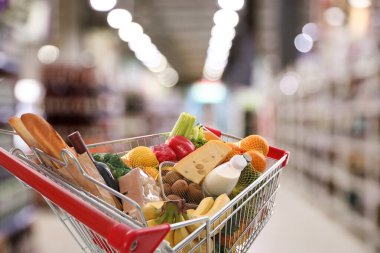 Süpermarketteki ürünlerle dolu alışveriş arabası.