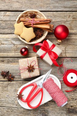 Kutlama ambalajı. Hediye kutuları, sicim, makas, kurabiye, baharat ve takılar tahta masada, düz bir şekilde. Mutlu Noeller ve mutlu yıllar.