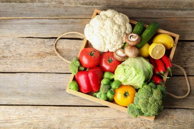 Tahta masada taze taze sebzeler ve meyveler var. Metin için boşluk