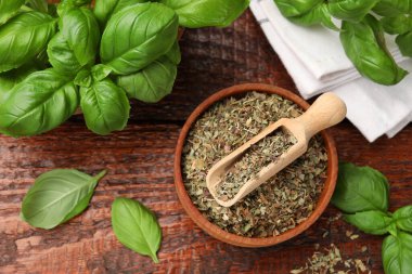 Kuru fesleğen yaprakları ve taze yapraklar ahşap masada, düz yatıyordu.