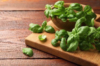 Tahta masada taze fesleğen yaprakları, yakın plan. Metin için boşluk