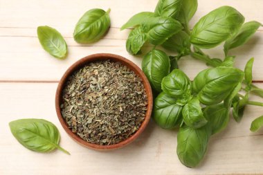 Kuru fesleğen yaprakları, taze olanlar ve yuvarlak tahta masa, düz uzanma