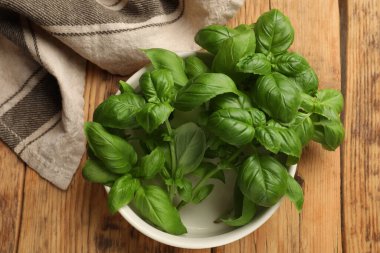 Tahta masanın üstünde taze fesleğen yaprakları, üst manzara.