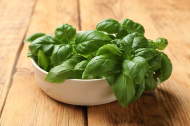 Tahta masada taze fesleğen yaprakları, yakın plan.