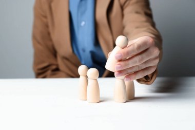 Beyaz ahşap masada insan figürlü bir kadın, yakın plan.