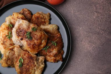 Lezzetli pişmiş tavuk butları ve kahverengi masa, üst manzara. Metin için boşluk