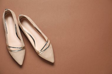 Kahverengi arka planda bir çift şık ayakkabı, üst manzara. Metin için boşluk