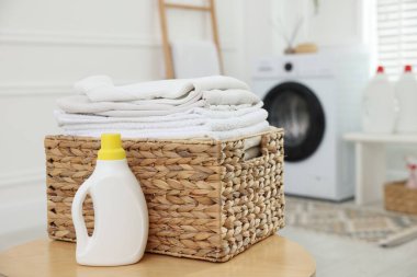 Temiz elbiseli çamaşır sepeti ve kapalı alanda deterjan.