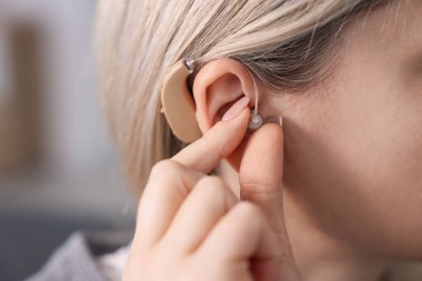 Evde işitme cihazı olan bir kadın, yakın çekim. Metin için boşluk