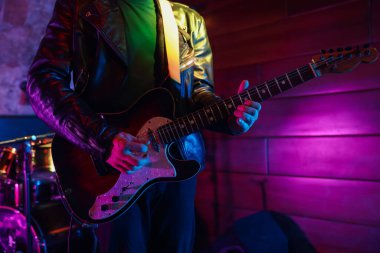 Sahnede elektro gitar çalan adam, yakın plan.