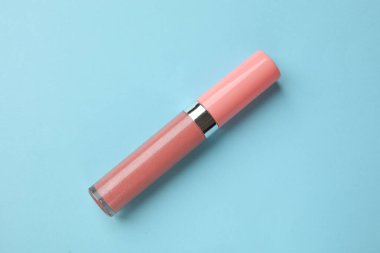 Açık mavi arkaplanda güzel dudak parlatıcısı, üst görünüm