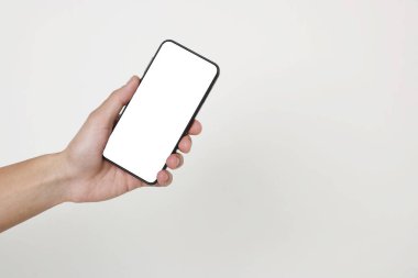 Man holding smartphone with blank screen on white background, closeup. Mockup for design