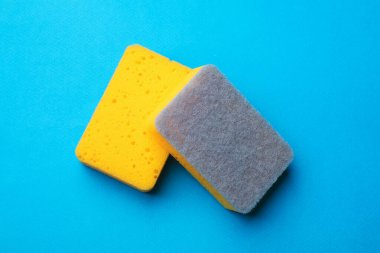 Kitchen sponges on light blue background, top view