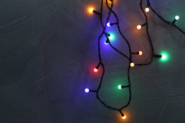 Gri desenli masada parlak Noel ışıkları, üst manzara. Metin için boşluk