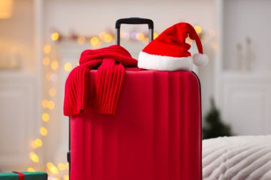 Noel tatili. İçinde Noel Baba şapkası ve eşarp olan bavul, yakın plan.
