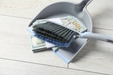 Süpürge ve dolar banknotları olan faraş. Kapalı alanda, yakın plan. Metin için boşluk