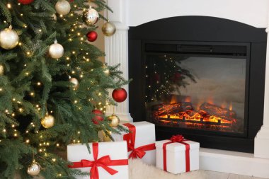 Noel ağacı, şenlikli bir dekor ve şık bir odada şömine. İç tasarım