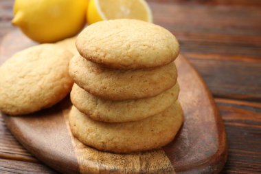 Lezzetli limonlu kurabiyeler ve meyveler ahşap masada, yakın plan.